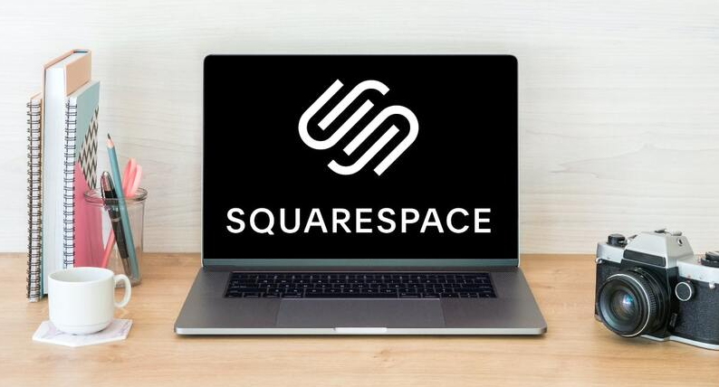 Shopify vs. Squarespace vs. WooCommerce: Which E-commerce Platform is Best for SMEs 5 A laptop showcasing the Squarespace logo rests on a wooden desk. Nearby, a potted plant, stationery holder, coffee cup, and vintage camera complete the scene against a light wooden wall backdrop. | Ven Agency